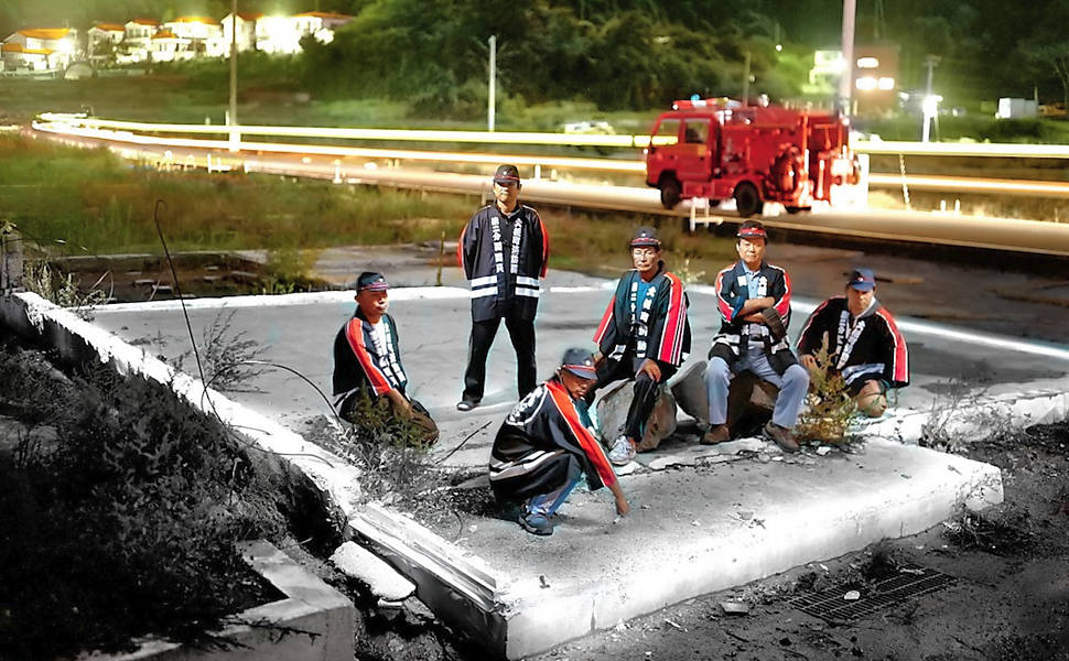 Os bombeiros da cidade japonesa se sentam no local onde era o prédio do órgão, em imagem do fotógrafo Alejandro Chaskielberg