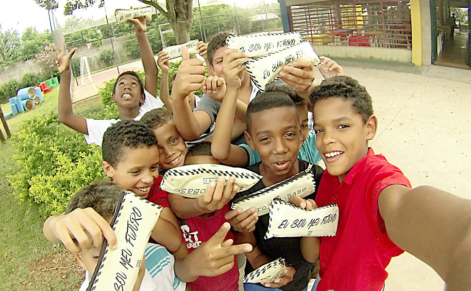 Crianças atendidas pela ONG Obra do Berço, na Grande São Paulo, recebem estojos doados pela grife Oriba. A cada peça vendida no site da marca um kit escolar é distribuído