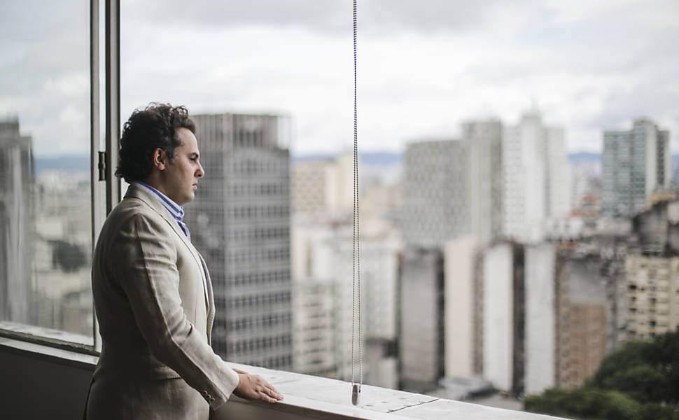 O médico Bruno Levenhagen, 40, olha pela janela de seu apartamento na República, no centro de São Paulo