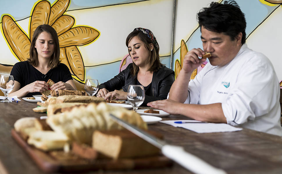A padeira Flavia Maculan, a repórter Magê Flores e o padeiro e professor Rogerio Shimura durante degustação de pães na escola Levian