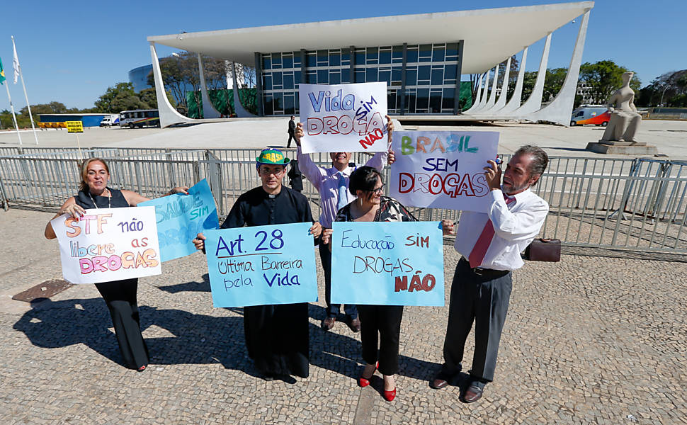 Manifestantes contra à descriminalização do porte de drogas seguram cartazes em frente ao STF
