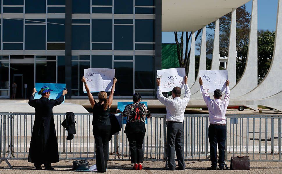 Manifestantes contrários à descriminalização do porte de drogas seguram cartazes em frente ao STF