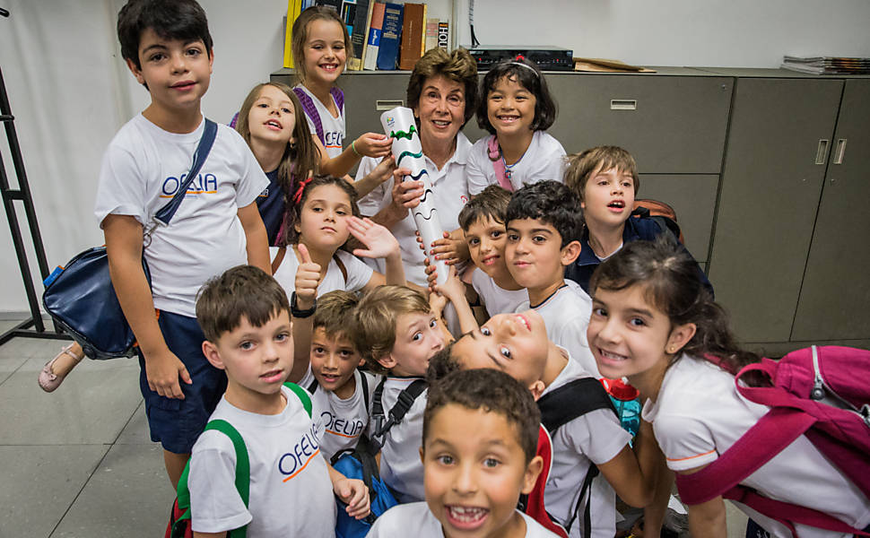 Maria Esther posa para foto com crianças que visitavam a sede da Folha ao mesmo tempo que ela