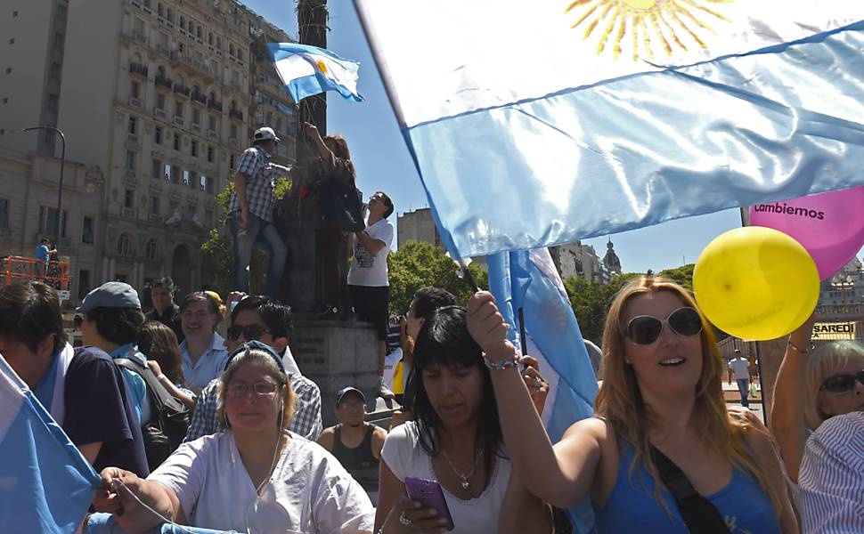 Simpatizantes de Macri carregam bandeiras argentinas e balões amarelos e rosas, marca da coalizão Mudemos