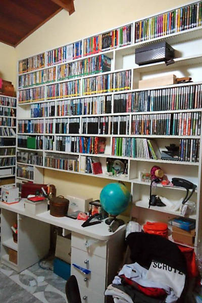 Prateleira no escritório com o acervo de CDs e DVDs
