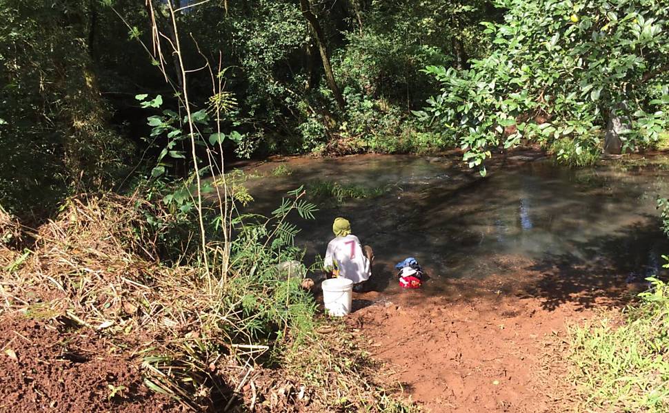 Vista de córrego ao lado de alojamento usado como fonte de água; trabalhadores não tinham registro em carteira