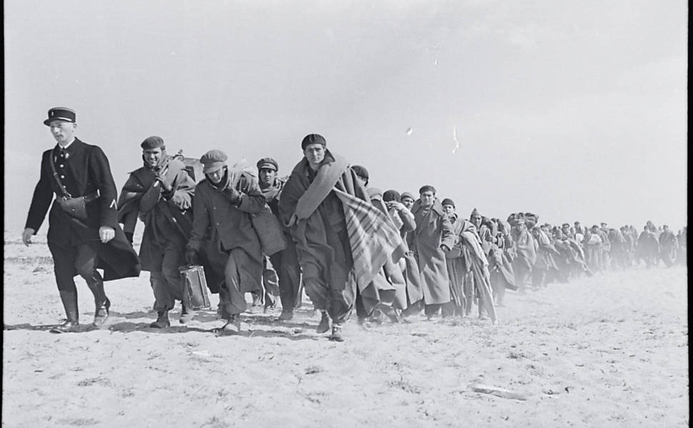 Refugiados andando na praia.Campo de internação francês para exilados republicanos, Le Barcarès, França. Março de 1939.