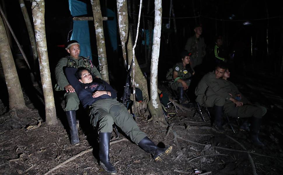 Soldados rebeldes das Farc assistem à televisão na floresta ao sul de Putumayo, Colômbia