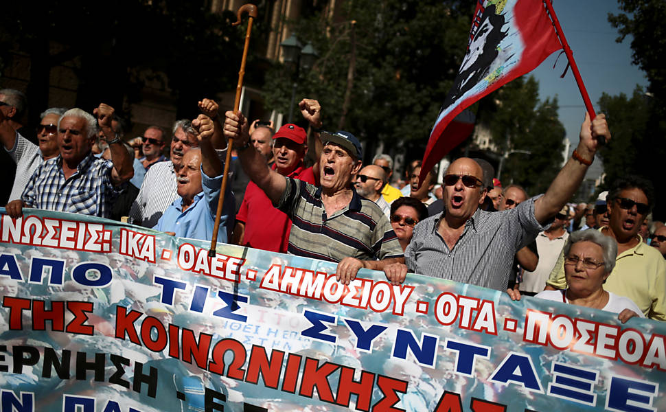 Pensionistas seguram cartazes e faixas contra os cortes