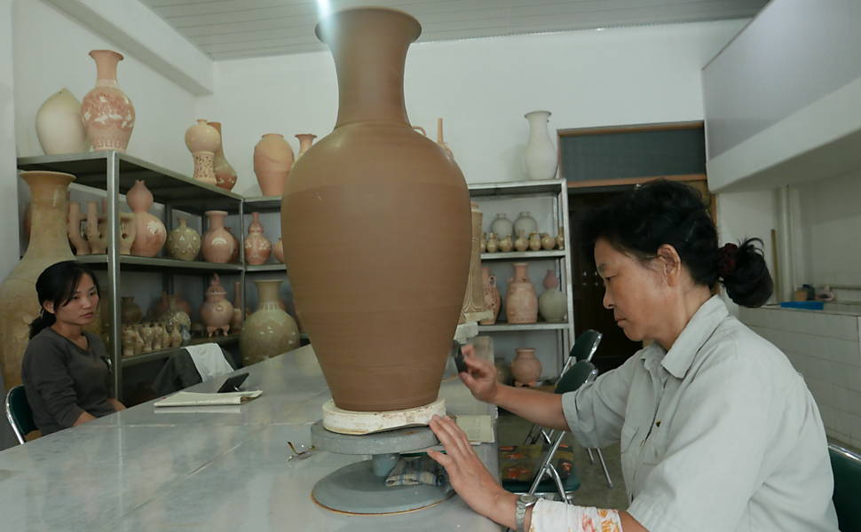 Norte-coreanos trabalham no Mansudae Art Studio, grande complexo de produção em massa de obras de arte e artesanato