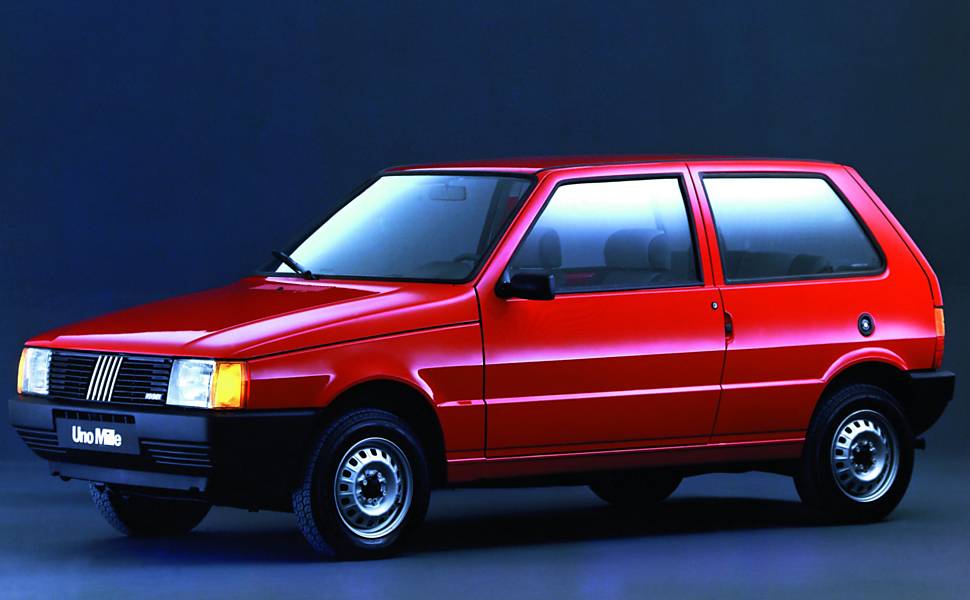 1990 - O Fiat Uno Mille estreia com motor de 48 cv e pacote de equipamentos bastante limitado. Não havia nem sequer retrovisor do lado direito