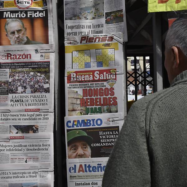 Homem lê as primeiras páginas dos jornais em um banca em La Paz, na manhã seguinte à morte de Fidel Castro, aos 90 anos