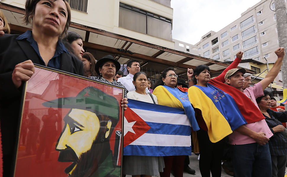 Pessoas se reúnem com bandeira nacional de Cuba e do Equador na embaixada em Quito para prestar homenagem ao líder revolucionário Fidel Castro, que faleceu aos 90 anos neste sábado 