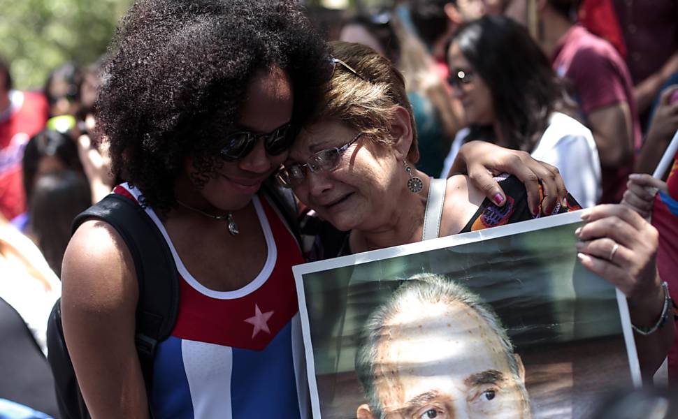Pessoas choram ao homenagear ao líder revolucionário cubano Fidel Castro na embaixada cubana em Santiago do Chile