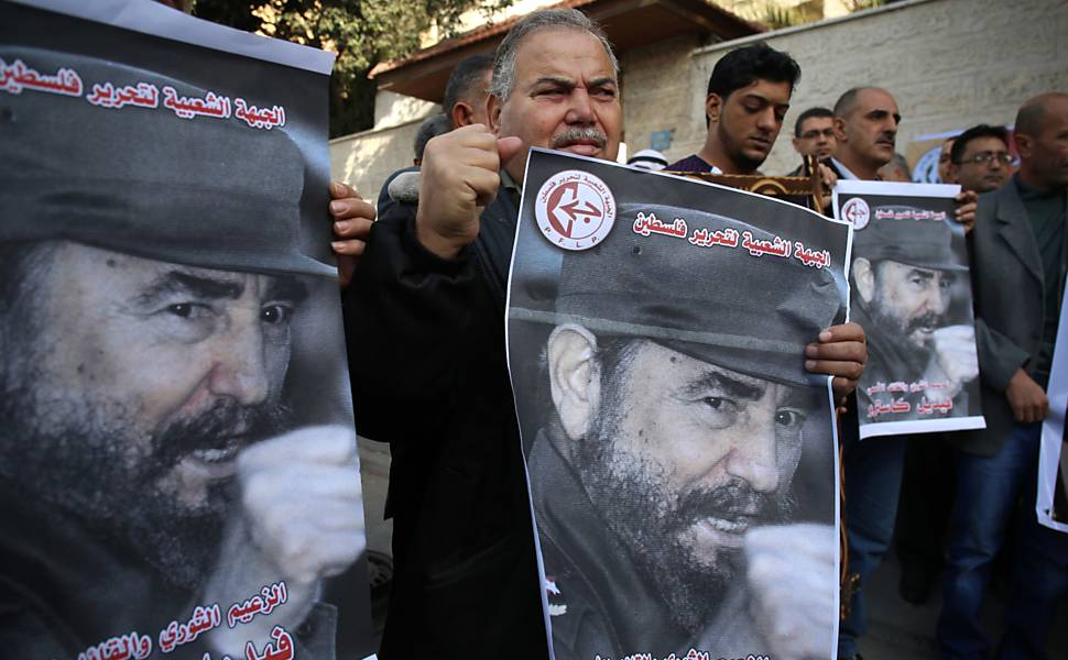 Homens palestinos levam posteres do falecido líder cubano Fidel Castro  para prestar homenagem a ele em Gaza