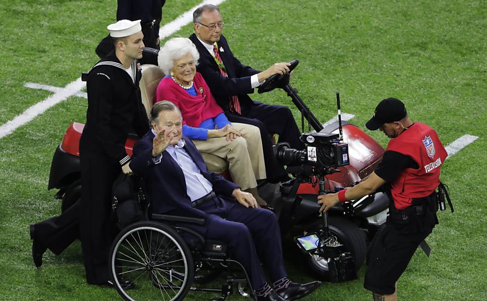 O ex-presidente americano George H.W. Bush e sua mulher Barbara passeiam pelo campo antes do jogo 