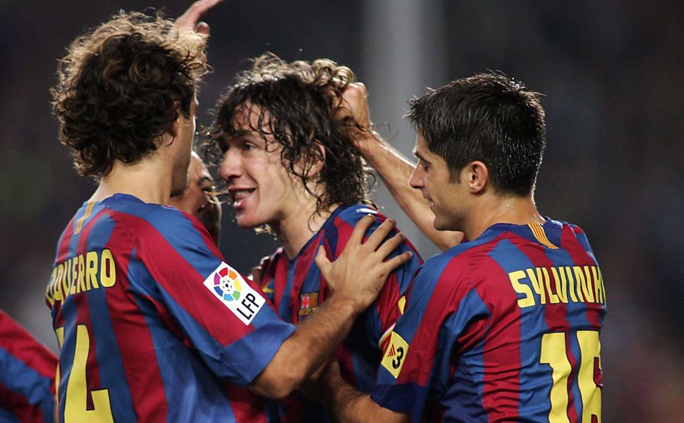 Sylvinho (à dir.) foi campeão em 2006 e 2009. Na primeira decisão, ficou no banco. Na segunda, foi titular