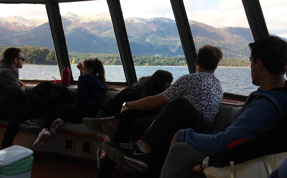 Turistas observam a paisagem da Patagônia de dentro de catamarã no lago Nahuel Huapi