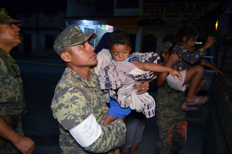 Soldados ajudam moradores a evacuar bairro atingido, em Puerto Madero