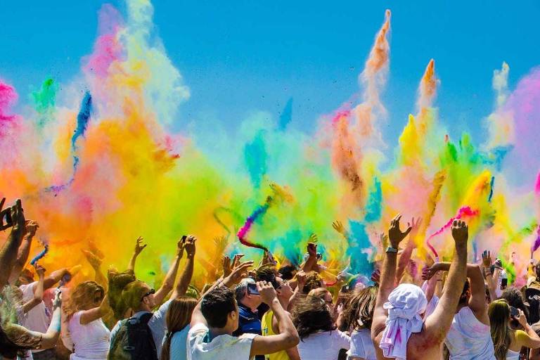 Muitos indianos jogando tinta em pó para o ar holi festival