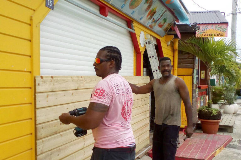 Men board up buildings ahead of Hurricane Maria in Sainte-Anne on the French Caribbean island of Guadeloupe, Monday, Sept. 18, 2017. Hurricane Maria grew into a Category 3 storm on Monday as it barreled toward a potentially devastating collision with islands in the eastern Caribbean. (AP Photo/Dominique Chomereau-Lamotte) ORG XMIT: TSX104