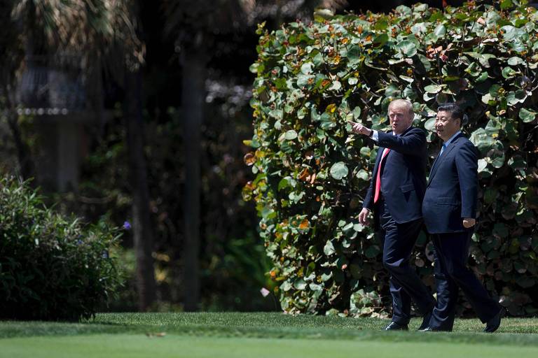 US President Donald Trump (L) and Chinese President Xi Jinping (R) walk together at the Mar-a-Lago estate in West Palm Beach, Florida, April 7, 2017. President Donald Trump entered a second day of talks with his Chinese counterpart Xi Jinping on Friday hoping to strike deals on trade and jobs after an overnight show of strength in Syria. / AFP PHOTO / JIM WATSON ORG XMIT: JIM008