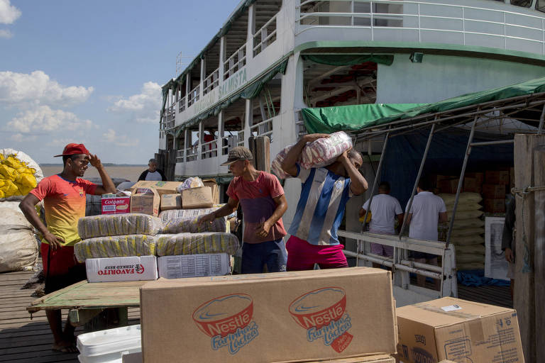 Carregadores carregam barco com produtos da Nestlé para serem distribuídos na região amazônica