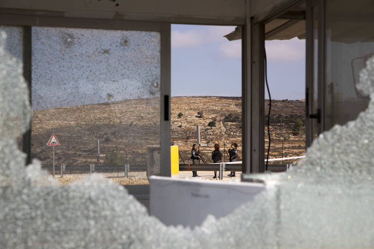 Agentes de segurana israelense conversam aps ao de palestino que deixou trs mortos na Cisrjodnia