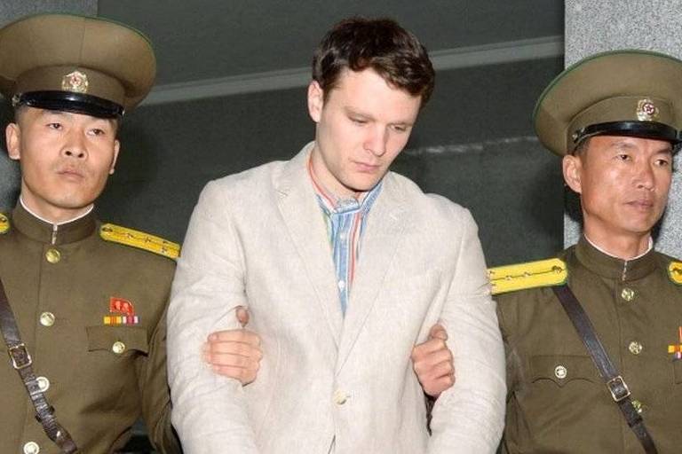 Otto Warmbier, escoltado por guardas no momento de sua prisão na Coreia do Norte, em imagem divulgada em março de 2016