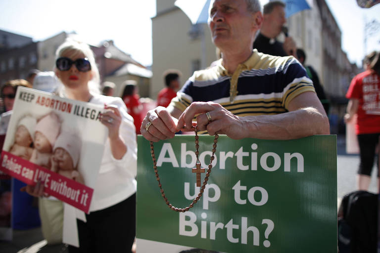 This file photo taken on July 10, 2013 shows Protesters hold a anti-abortion placards in front of the gates of the Irish Parliament building in Dublin during a demonstration ahead of a vote to introduce abortion in limited cases where the mother's life is at risk. Ireland will hold a referendum next year on whether to repeal its constitutional ban on abortion in almost all cases, Prime Minister Leo Varadkar's government announced on September 26, 2017. / AFP PHOTO / PETER MUHLY ORG XMIT: ABT003
