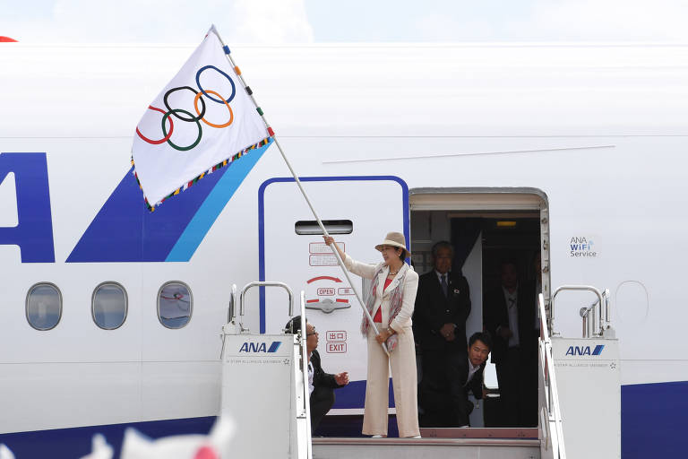 Ao chegar ao Aeroporto Internacional de Haneda, em Tóquio, a governadora Yuriko Koike acena com a bandeira olímpica que recebeu na cerimônia de encerramento dos Jogos Olímpicos do Rio 2016