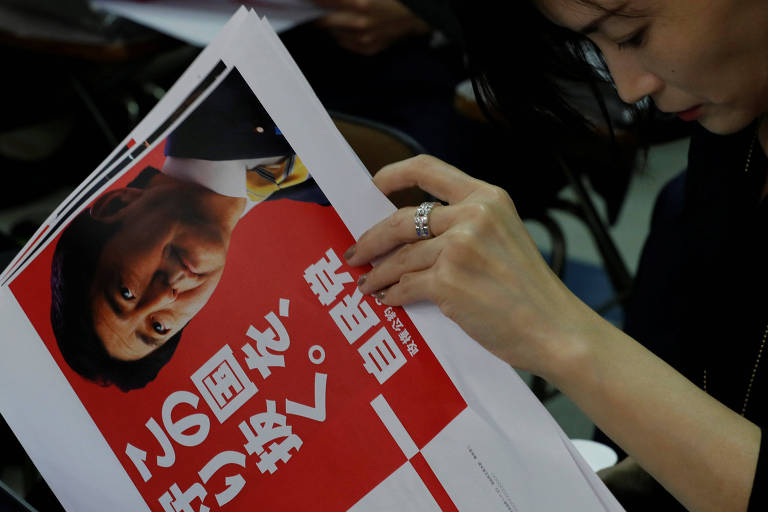 A reporter looks at a leaflet of ruling Liberal Democratic Party's (LDP) election campaign with printed face of Japan's Prime Minister Shinzo Abe, during a news conference at the LDP's headquarters in Tokyo, Japan, October 2, 2017. REUTERS/Kim Kyung-Hoon ORG XMIT: TOK005