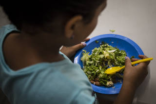 Criança come merenda escolar da Escola Estadual Maria José