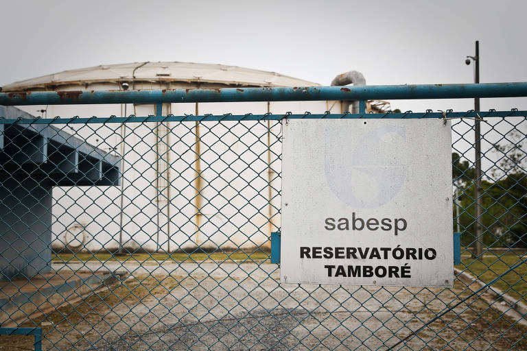 Imagem mostra grade de arame com placa "Sabesp Reservatório Tamboré".
