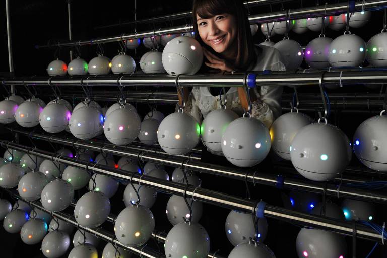 ORG XMIT: TOK928 Minami Sawada, an employee of Japanese weather forecasting company Weathernews displays some of the 1,000 pod-shaped pollen counting robots called 