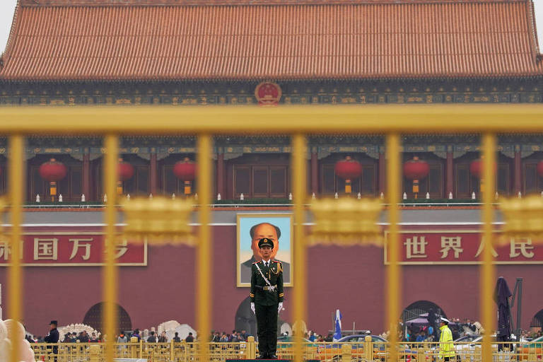 Policial paramilitar fica de guarda em frente ao retrato de Mao Zendong, no portão de Tiananmen, em Pequim