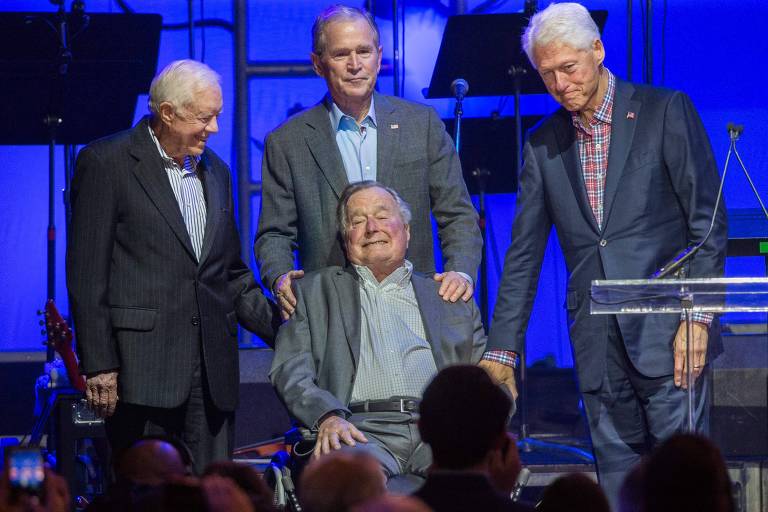 FILES) This file photo taken on October 21, 2017 shows (L-R) Former US Presidents, Jimmy Carter, George H. W. Bush, George W. Bush, and Bill Clinton attending the Hurricane Relief concert in College Station, Texas. "Former US President George HW Bush has issued an apology to an actress who accused him of groping her from his wheelchair while attending a screening, according to reports. Heather Lind, 34, said the incident occurred four years ago at an event to promote the TV series "Turn: Washington's Spies," according to the Daily Mail, which saved a screenshot of a lengthy Instagram post she wrote and later deleted.It is the latest in an outpouring of sexual harassment allegations against powerful male figures in entertainment, fashion and finance that followed the downfall of movie mogul Harvey Weinstein, who stands accused of assaulting and raping actresses. / AFP PHOTO / JIM CHAPIN