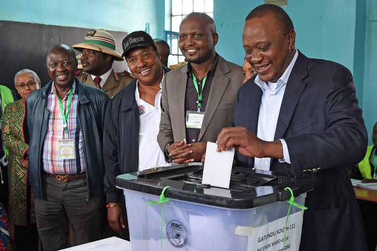 O presidente do Qunia, Uhuru Kenyatta (direita), vota em Nairbi