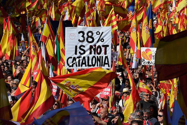 TOPSHOT - Protesters wave Spanish and Catalan Senyera flag while holding a sign reading "38 percent is not Catalonia" in reference to a referendum voter turnout during a pro-unity demonstration in Barcelona on October 29, 2017. Pro-unity protesters were to gather in Catalonia's capital Barcelona, two days after lawmakers voted to split the wealthy region from Spain, plunging the country into an unprecedented political crisis. / AFP PHOTO / LLUIS GENE ORG XMIT: LLG1407