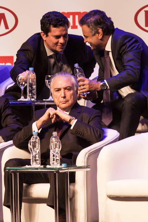 Em dezembro de 2016, o juiz Sergio Moro conversa com o senador Aécio Neves (PSDB) durante a cerimônia de entrega do prêmio Brasileiro do Ano, em São Paulo; o presidente Michel Temer (à frente) também foi homenageado