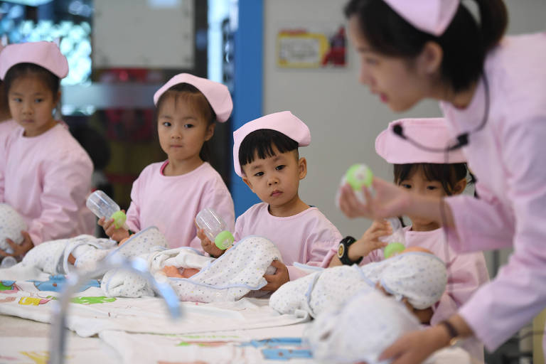 Crianas treinam cuidar de um beb, em Hangzhou, no leste da China