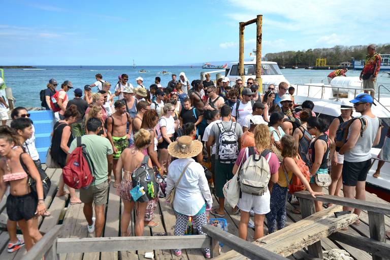 Turistas estrangeiros chegam ao porto de Padangbai, na ilha indonsia de Bali