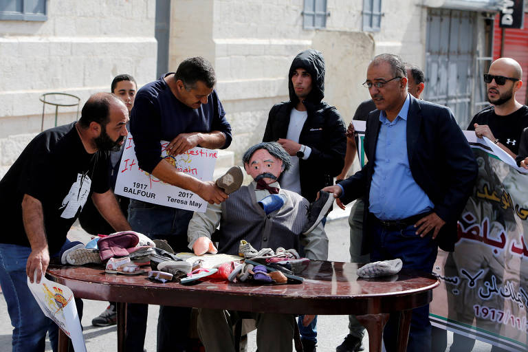 Palestinos usam sapatos para bater em boneco de Arthur Balfour em protesto na Cisjordnia