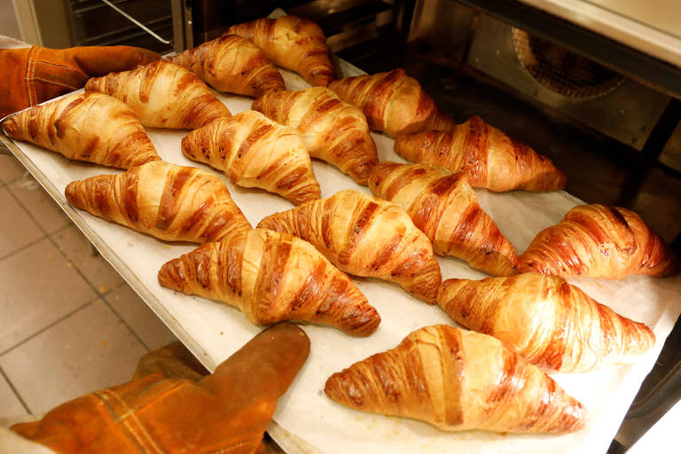 Funcionrio retira fornada de croissants em loja da rede La Croissanterie, em Paris