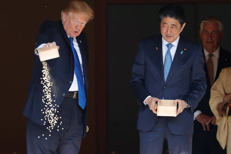 O presidente dos EUA Donald Trump e o premi japons Shinzo Abe alimentam carpas em Tquio 