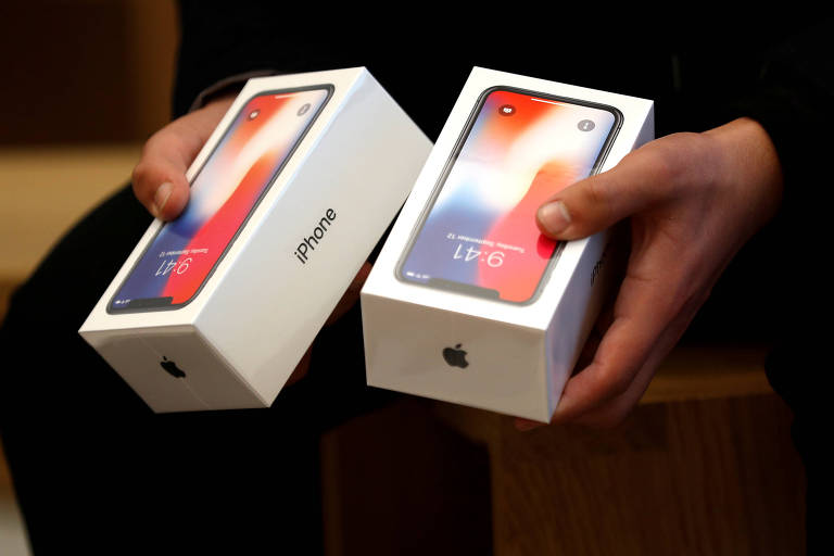 Homem segura duas caixas do novo iPhone X em loja da Apple em Londres