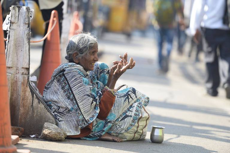 Mulher pede esmola nas ruas de Hyderabad, no sul da ndia; cidade esconde moradores de rua antes de cpula
