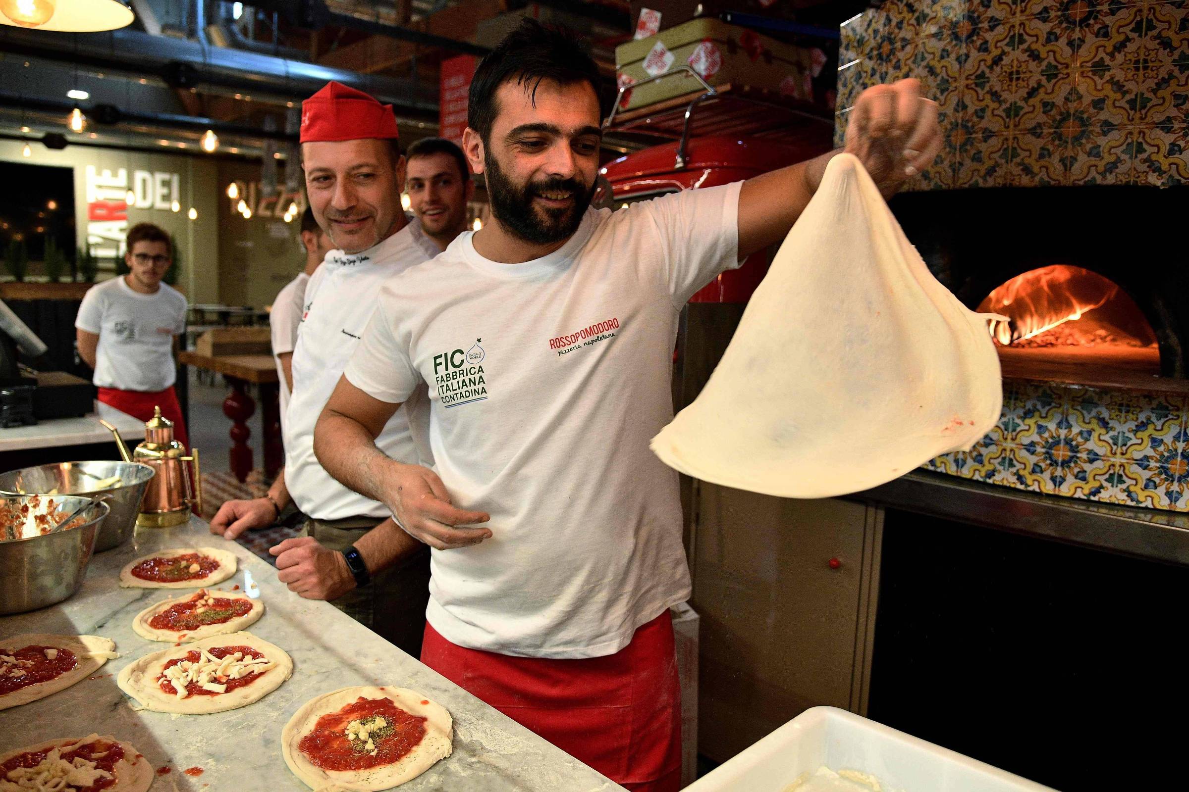 Garçonete bonita servindo grupo de amigas com comida no restaurante