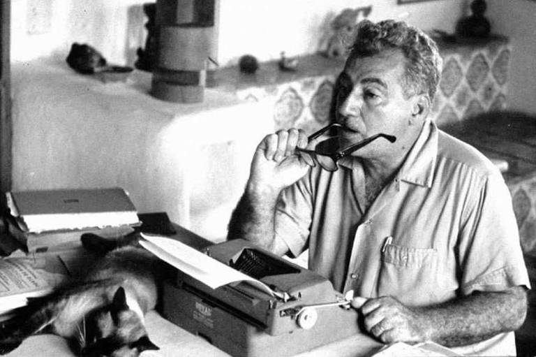 Jorge Amado (1912-2001) com seu gato Nacib enquanto escreve "Dona Flor e Seus Dois Maridos"