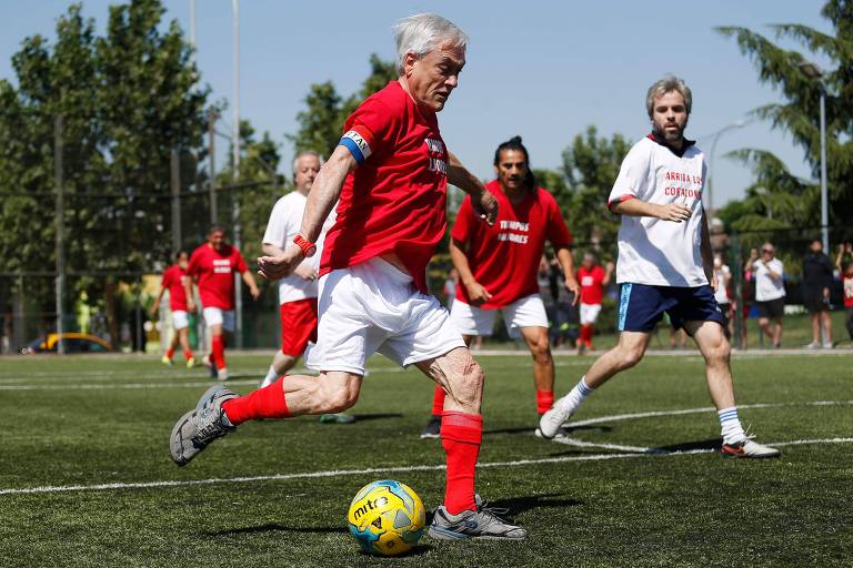 O candidato à Presidência do Chile Sebastián Piñera (centro-direita) joga amistoso de futebol na véspera da eleição, em Santiago